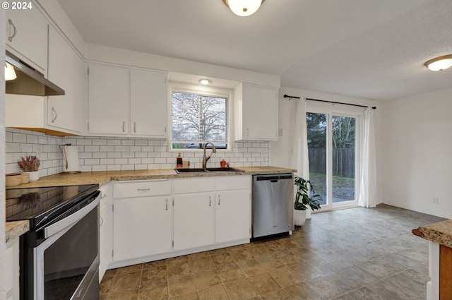 kitchen with tasteful backsplash, sink, stainless steel appliances, and white cabinets