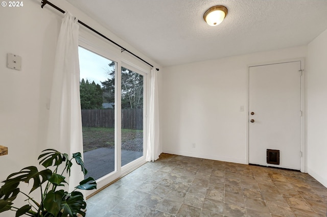 unfurnished room with a textured ceiling