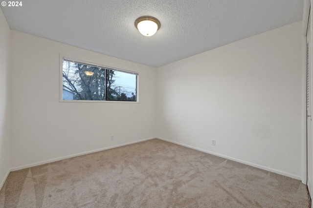 carpeted empty room with a textured ceiling