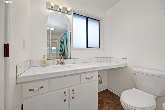 bathroom featuring vanity, plenty of natural light, and toilet