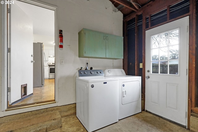 washroom featuring cabinets and washing machine and clothes dryer