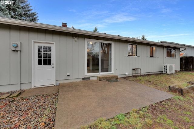 rear view of house with ac unit and a patio