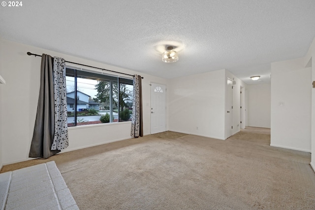 empty room featuring light carpet and a textured ceiling