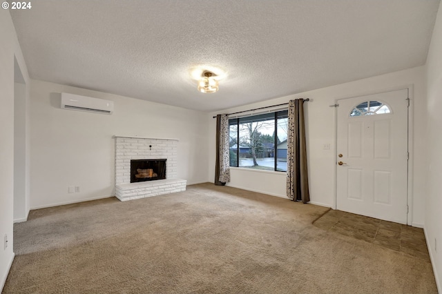 unfurnished living room featuring carpet floors, a fireplace, a wall unit AC, and a textured ceiling