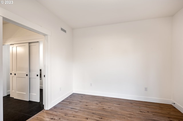 spare room with dark wood-type flooring