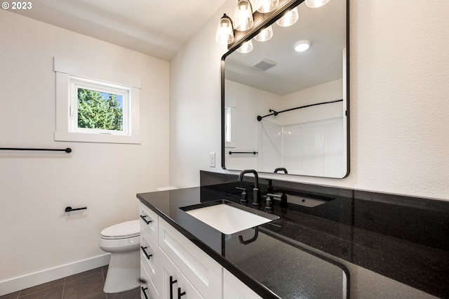 bathroom with tile patterned floors, toilet, vanity, and walk in shower