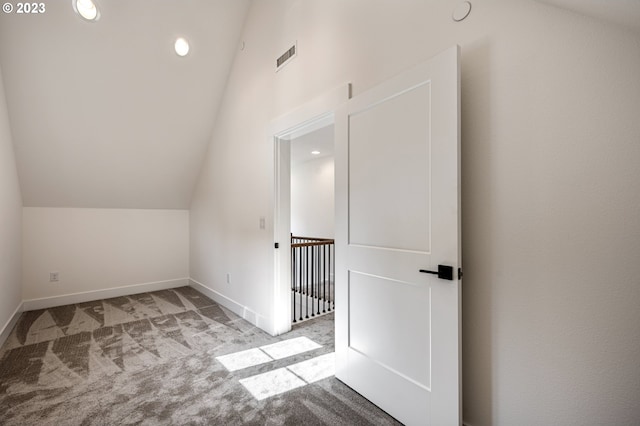 additional living space with light colored carpet and vaulted ceiling