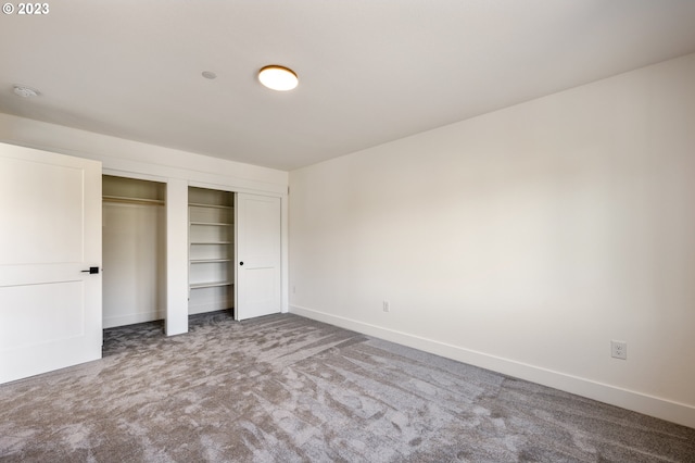 unfurnished bedroom featuring carpet flooring and a closet