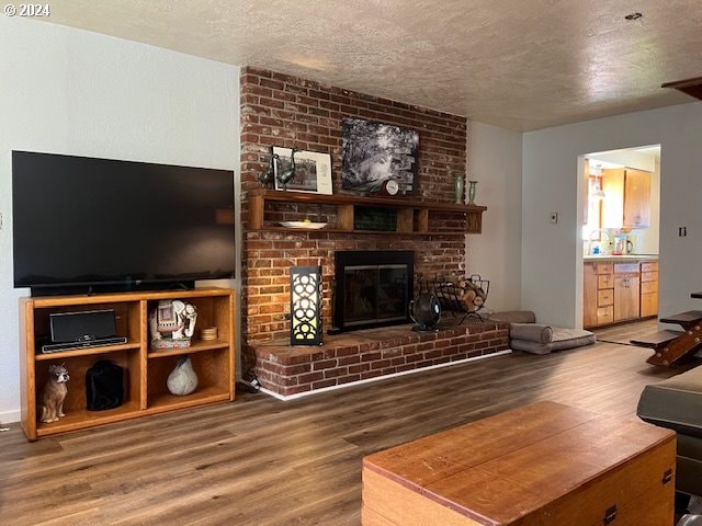 46791 Winfrey Rd, Westfir, OR 97492 - living room featuring wood finished floors, a textured ceiling, and a fireplace