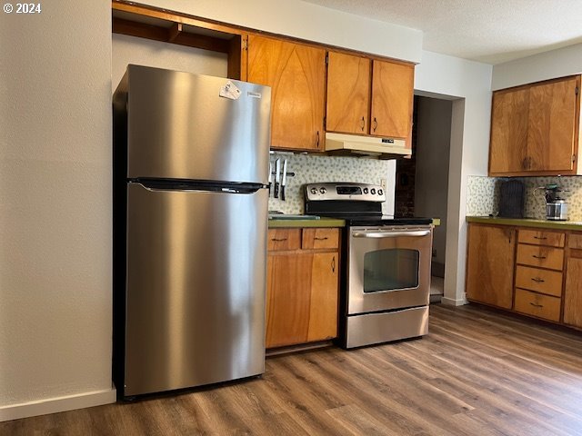 46791 Winfrey Rd, Westfir, OR 97492 - kitchen with stainless steel appliances, under cabinet range hood, decorative backsplash, and brown cabinetry