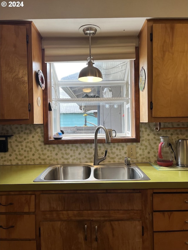 46791 Winfrey Rd, Westfir, OR 97492 - kitchen featuring a sink, light countertops, brown cabinetry, backsplash, and hanging light fixtures