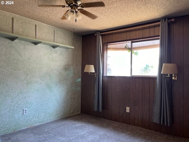 46791 Winfrey Rd, Westfir, OR 97492 - spare room with carpet, ceiling fan, wood walls, and a textured ceiling