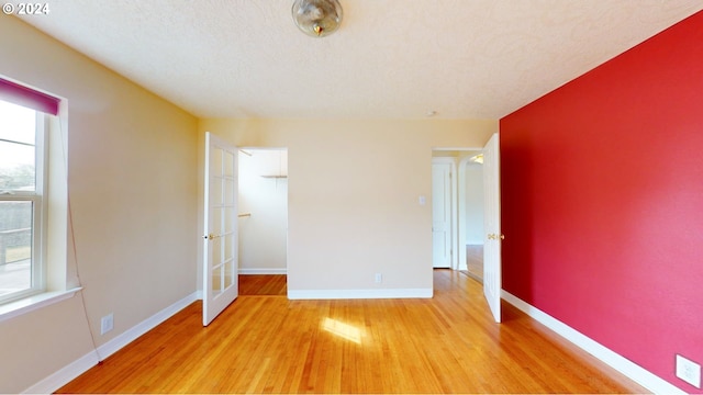 unfurnished bedroom featuring a textured ceiling and light hardwood / wood-style floors