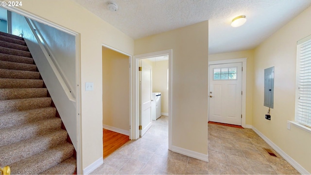 foyer entrance featuring a textured ceiling and electric panel