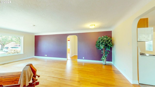 unfurnished room with a textured ceiling and hardwood / wood-style flooring