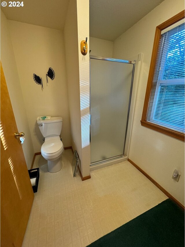 bathroom featuring toilet and walk in shower