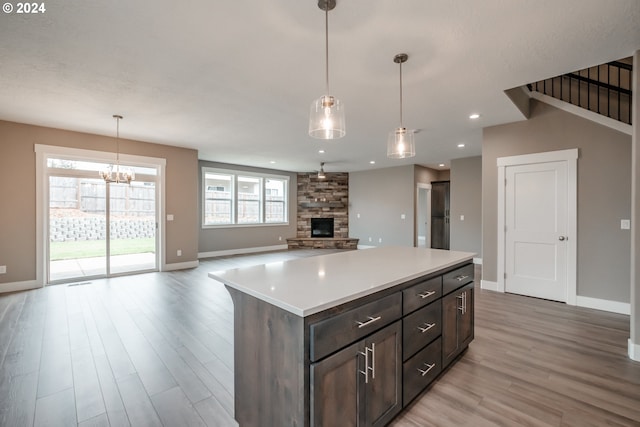 kitchen with hanging light fixtures, light hardwood / wood-style floors, and a healthy amount of sunlight