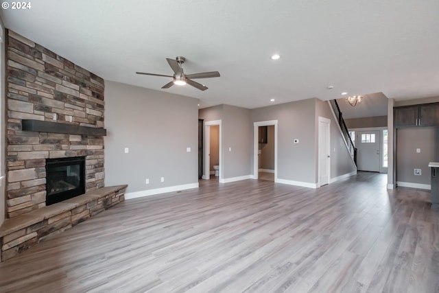 unfurnished living room with light wood-type flooring, ceiling fan, and a fireplace