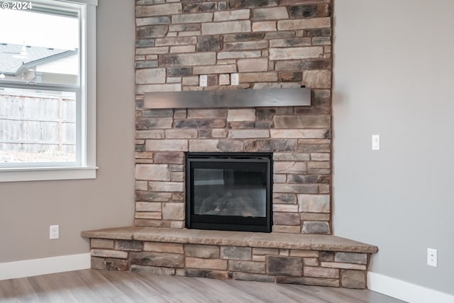 interior details with hardwood / wood-style floors and a stone fireplace