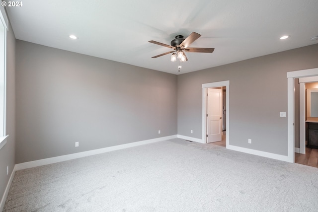 unfurnished bedroom with light colored carpet, ceiling fan, and ensuite bath