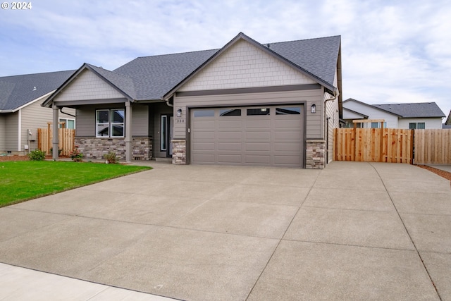 craftsman house featuring a garage and a front yard