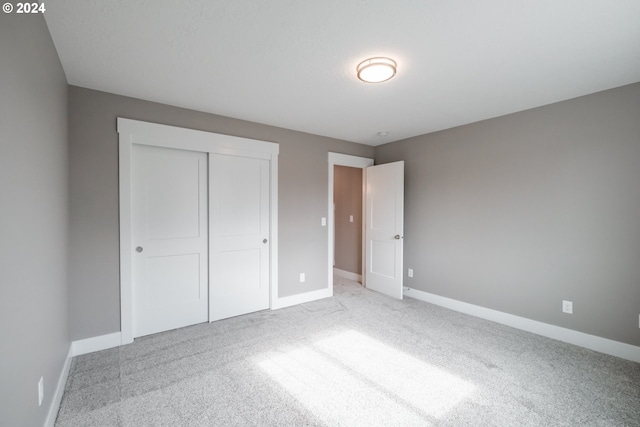 unfurnished bedroom featuring carpet floors and a closet