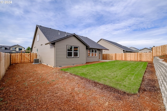 rear view of house with a yard and cooling unit