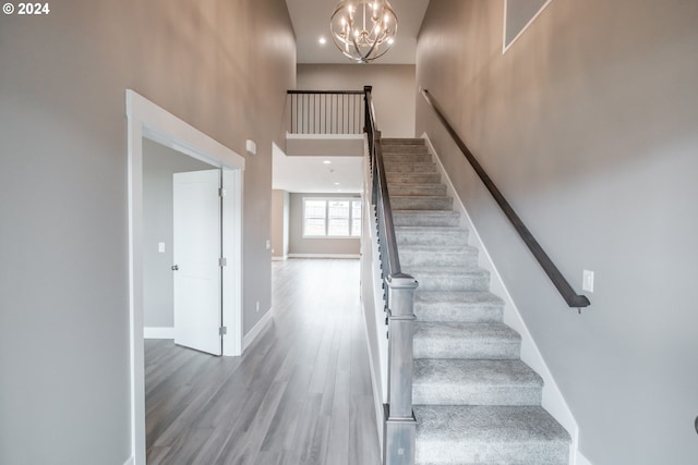 stairway featuring hardwood / wood-style floors and a high ceiling