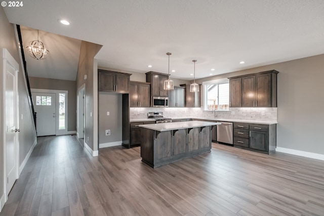 kitchen featuring stainless steel appliances, plenty of natural light, hardwood / wood-style floors, and a center island