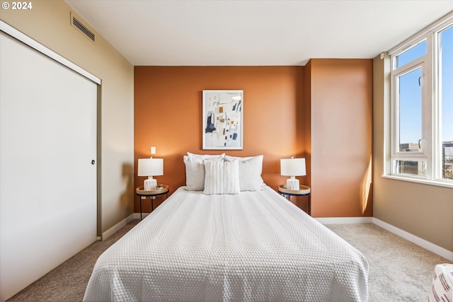 bedroom featuring light carpet and a closet