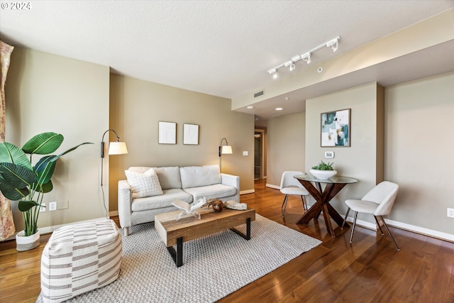 living room featuring a textured ceiling and wood-type flooring