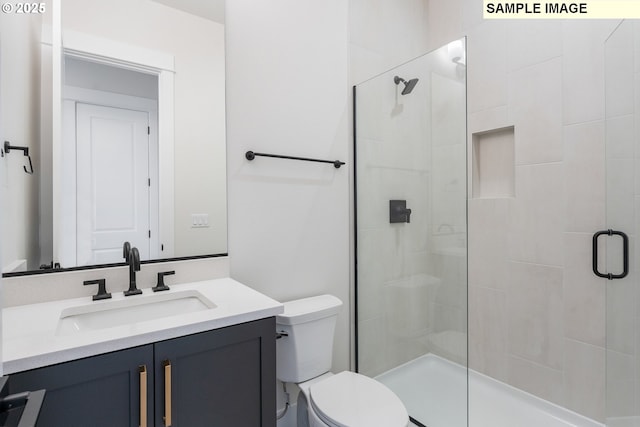 bathroom with vanity, toilet, and a stall shower