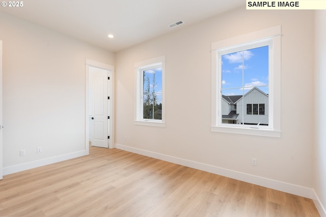 spare room with visible vents, recessed lighting, baseboards, and wood finished floors