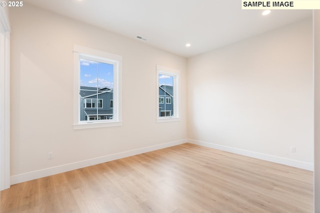 spare room featuring light wood-style flooring, recessed lighting, baseboards, and visible vents