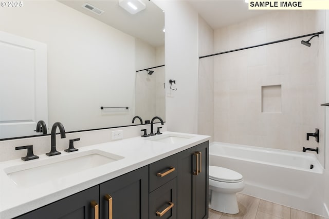 full bathroom with a sink, visible vents, toilet, and double vanity