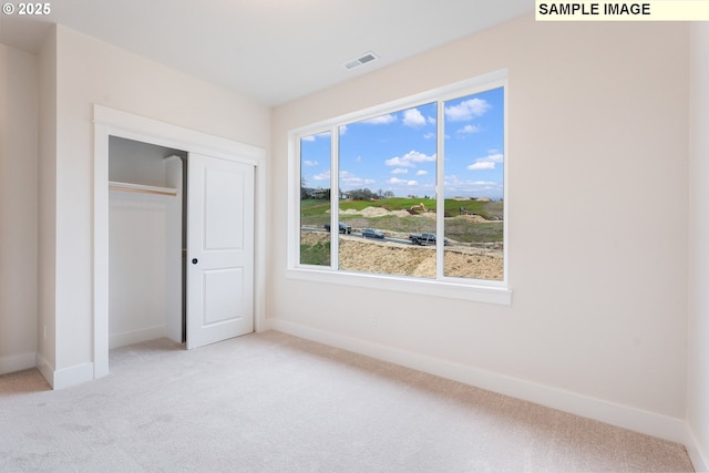 unfurnished bedroom featuring visible vents, baseboards, a closet, and carpet flooring