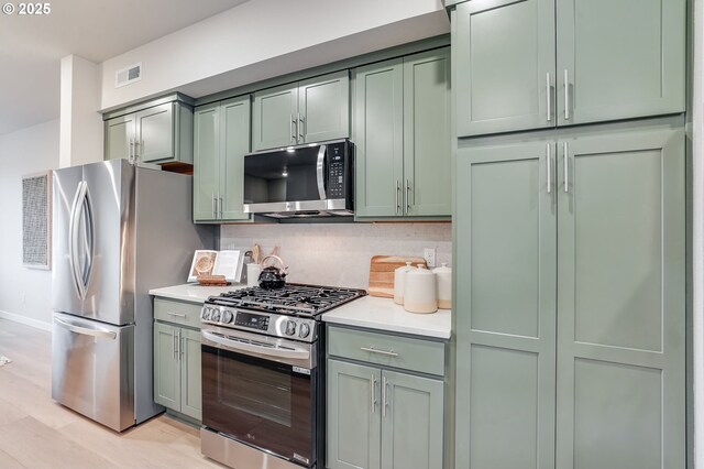 kitchen with light stone countertops, appliances with stainless steel finishes, a large island, and sink