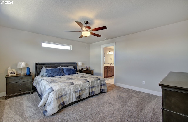 carpeted bedroom featuring ceiling fan, ensuite bathroom, and a textured ceiling