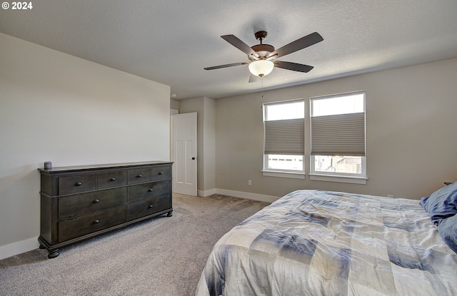 carpeted bedroom with ceiling fan and a textured ceiling