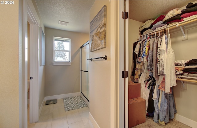 bathroom featuring an enclosed shower and a textured ceiling