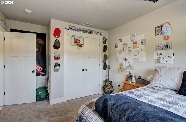 bedroom featuring carpet floors, a textured ceiling, and a closet