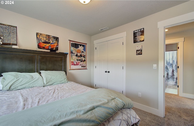 bedroom featuring carpet floors, a textured ceiling, and a closet