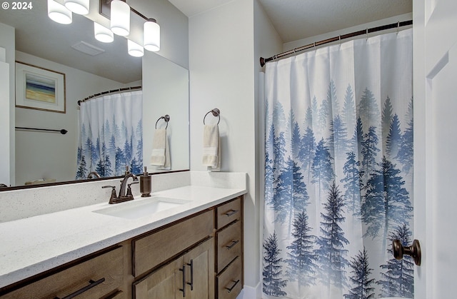 bathroom with an inviting chandelier, vanity, and walk in shower