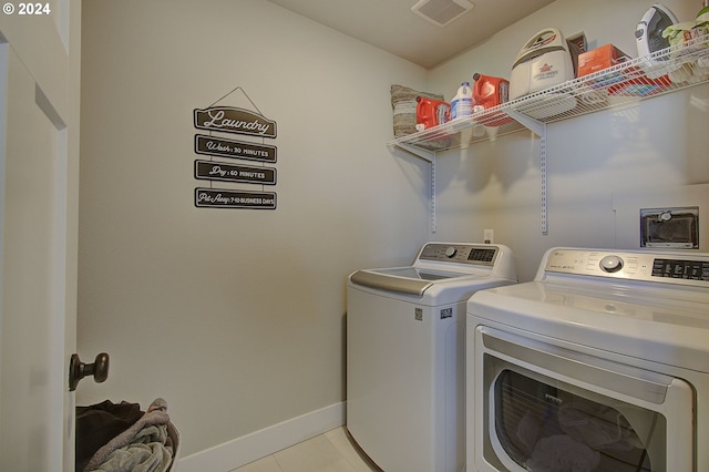 laundry room featuring light tile patterned flooring and separate washer and dryer