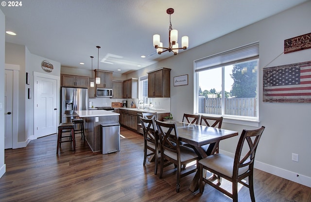 dining room with dark hardwood / wood-style floors, sink, and a notable chandelier