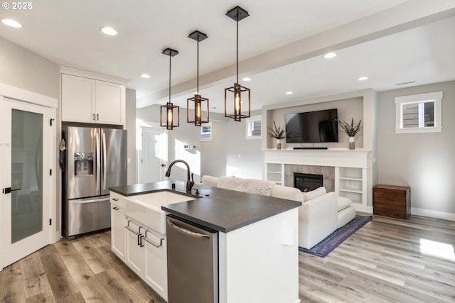 kitchen featuring white cabinetry, appliances with stainless steel finishes, and a center island with sink