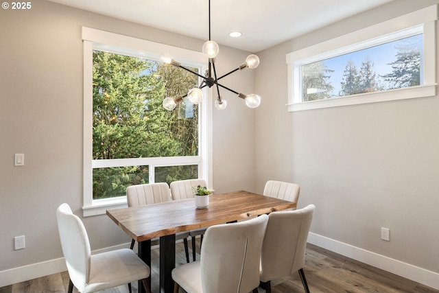 dining area with hardwood / wood-style flooring, an inviting chandelier, and a wealth of natural light