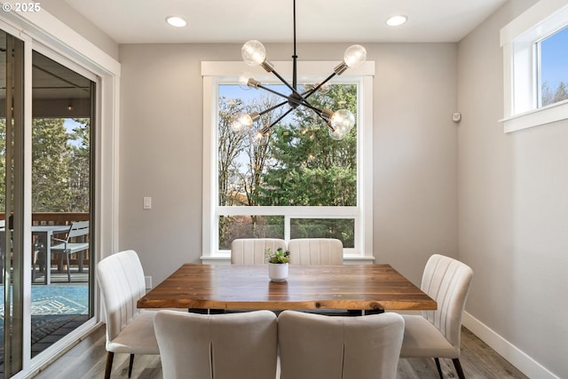 dining area featuring an inviting chandelier and hardwood / wood-style flooring