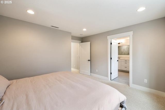 carpeted bedroom featuring ensuite bath