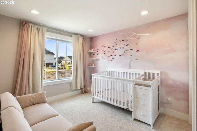 carpeted bedroom featuring a nursery area